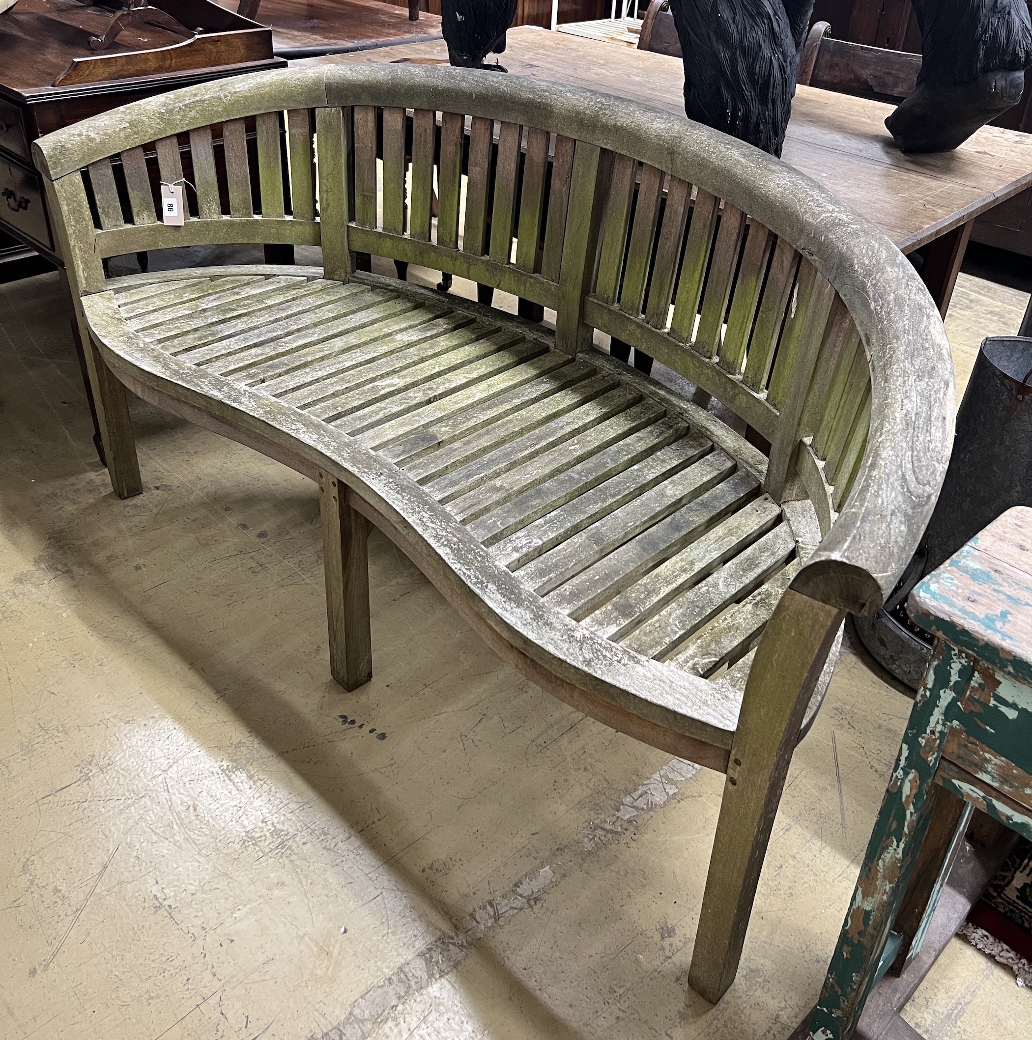 A weathered teak banana garden bench, length 162cm, depth 57cm, height 86cm